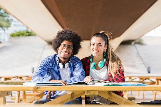 Retrato, de, interracial, par jovem, estudar, junto, em, ao ar livre