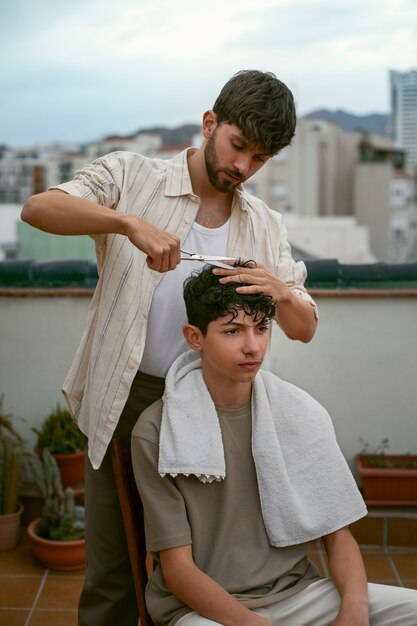 Retrato de irmãos ao ar livre durante uma sessão de corte de cabelo