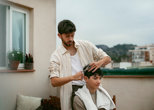 Foto grátis retrato de irmãos ao ar livre durante uma sessão de corte de cabelo