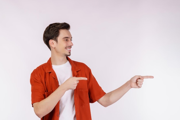 Retrato de jovem apontando os dedos para o espaço de cópia isolado no fundo branco do estúdio