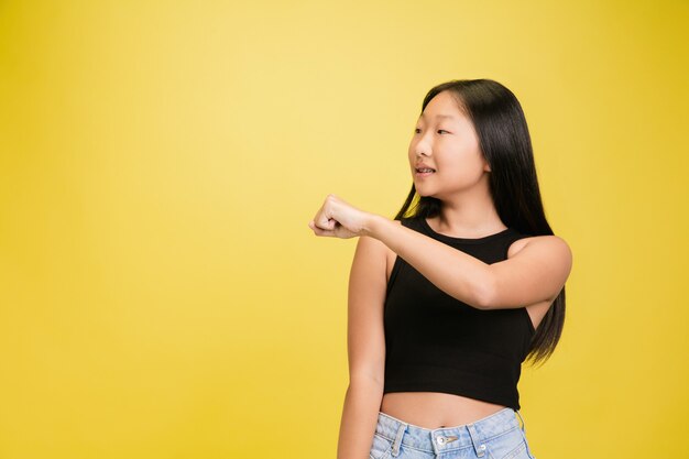 Retrato de jovem asiática isolada em estúdio amarelo