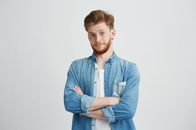 Retrato de jovem bonito com um sorriso de braços cruzados.