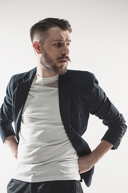 Retrato de jovem bonito elegante no estúdio contra branco. Homem vestindo jaqueta