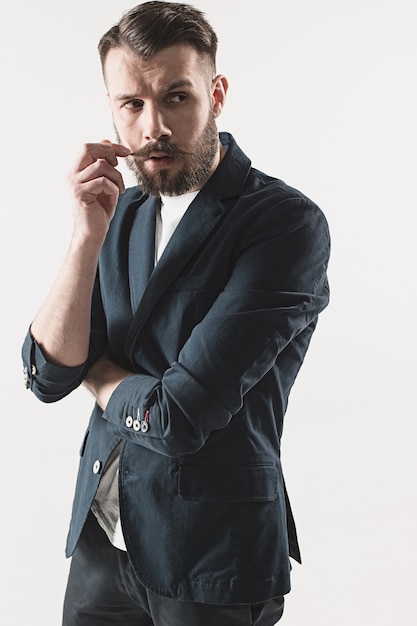 Retrato de jovem bonito elegante no estúdio contra branco. Homem vestindo jaqueta