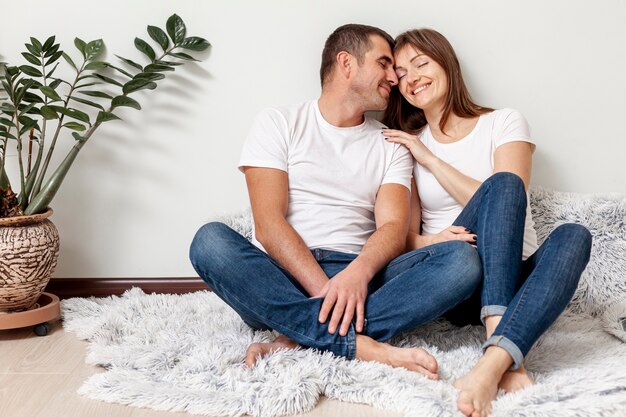 Retrato de jovem casal sentado no chão