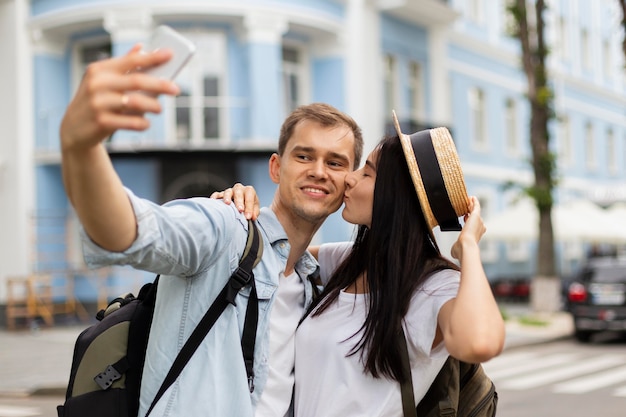 Foto grátis retrato de jovem casal tirando uma selfie ao ar livre