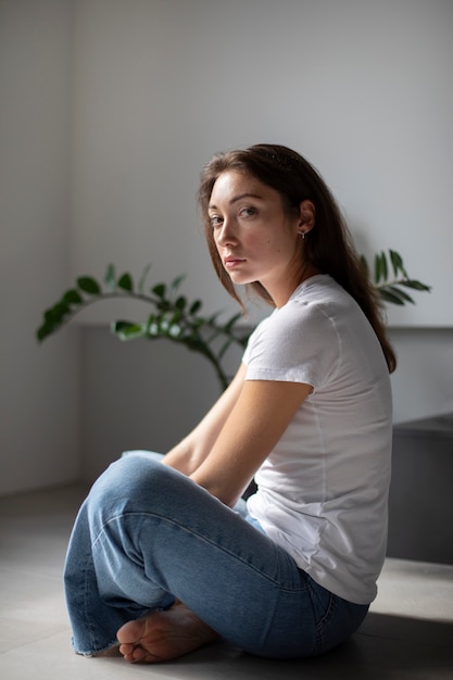 Retrato de jovem com baixa auto-estima sentado na sala em casa