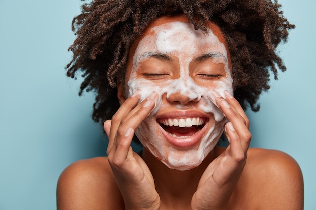 Foto grátis retrato de jovem com corte de cabelo afro, lavando a pele