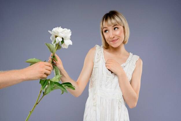 Retrato de jovem com flores sobre parede cinza