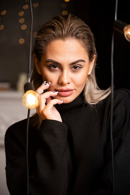 Retrato de jovem com suéter preto em pé e posando