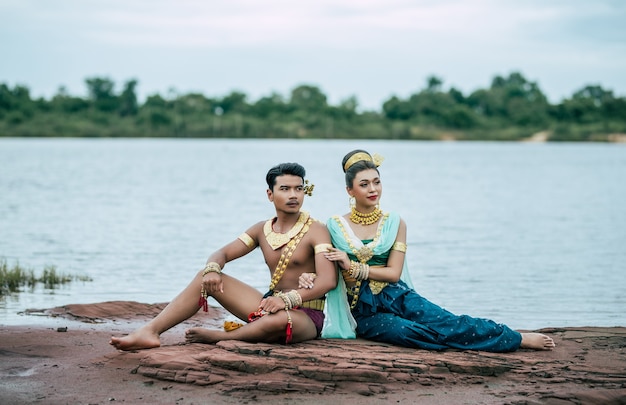 Retrato de jovem e mulher em traje tradicional posando na natureza na Tailândia
