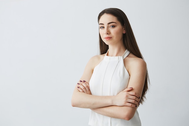 Retrato de jovem empresária linda com braços cruzados.