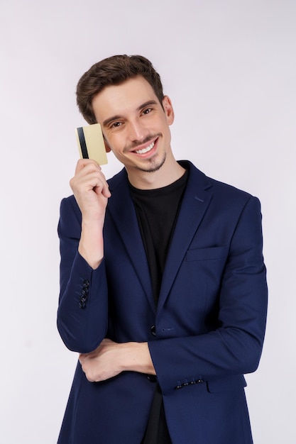 Foto grátis retrato de jovem empresário bonito sorridente mostrando cartão de crédito isolado sobre fundo branco