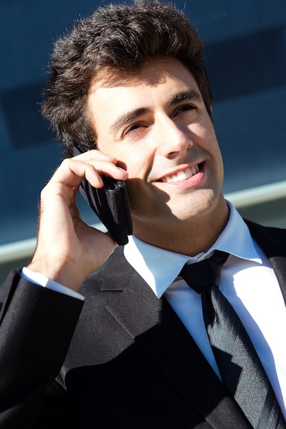 Retrato de jovem empresário falando com smartphone