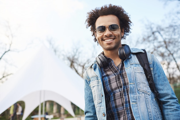 Retrato de jovem estudante afro-americano bonito com penteado afro sorrindo