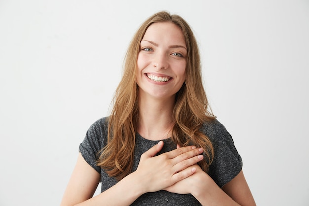 Retrato de jovem feliz concurso sorrindo de mãos dadas no coração.