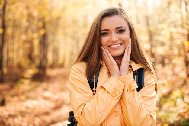 Retrato de jovem feliz durante uma caminhada de outono