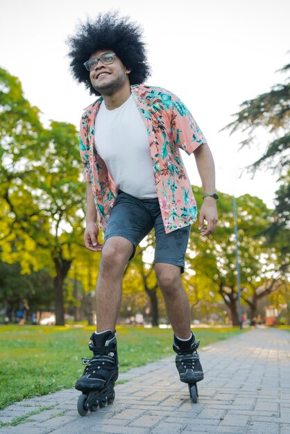 Retrato de jovem latino desfrutando enquanto patins ao ar livre na rua