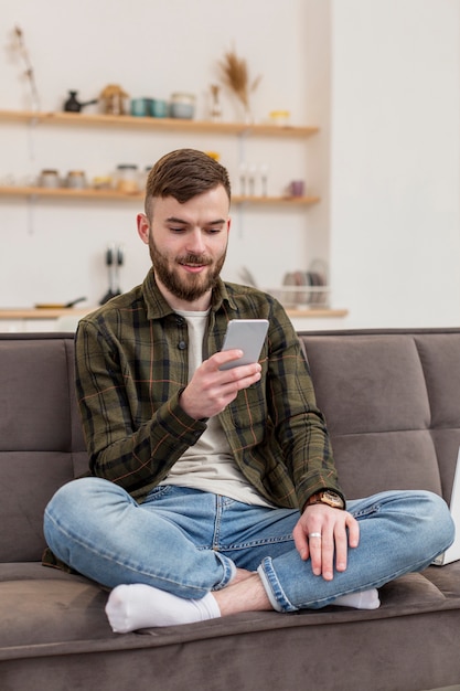 Retrato de jovem masculino navegação no telefone móvel