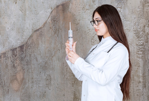 Retrato de jovem médico preparando seringas