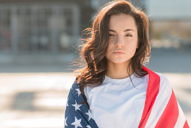 Foto grátis retrato de jovem morena segurando bandeira grande eua