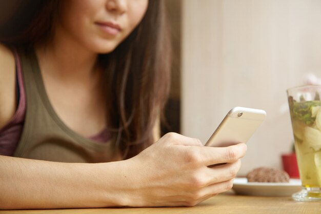 Retrato de jovem mulher morena, usando telefone