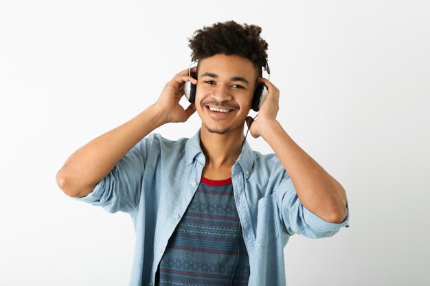 Retrato de jovem negro bonito ouvindo música em fones de ouvido em branco