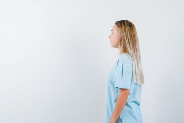 Retrato de jovem olhando para longe em uma camiseta e parecendo confiante com vista frontal