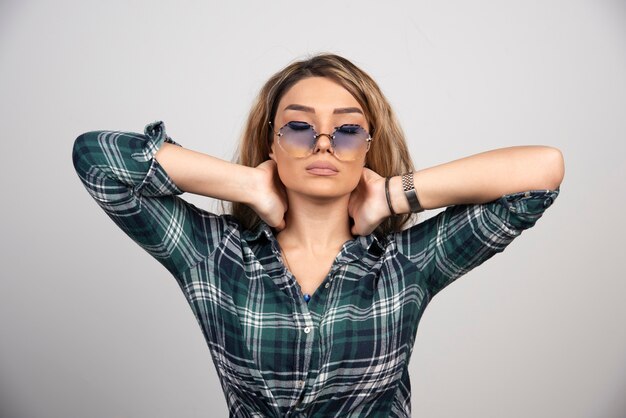 Retrato de jovem posando com óculos elegantes.