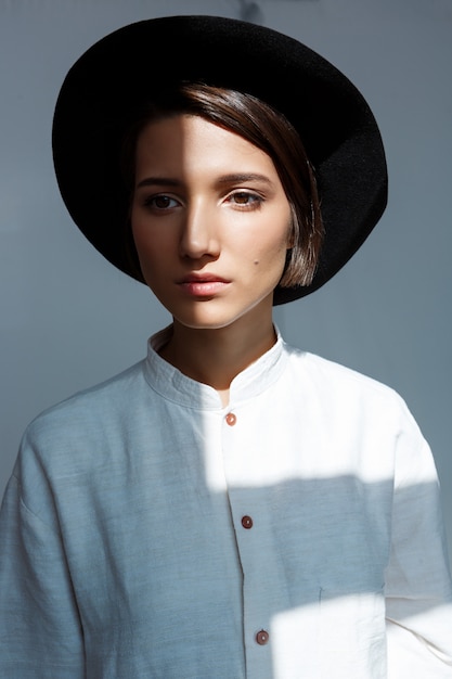 Retrato de jovem rapariga bonita de chapéu preto.