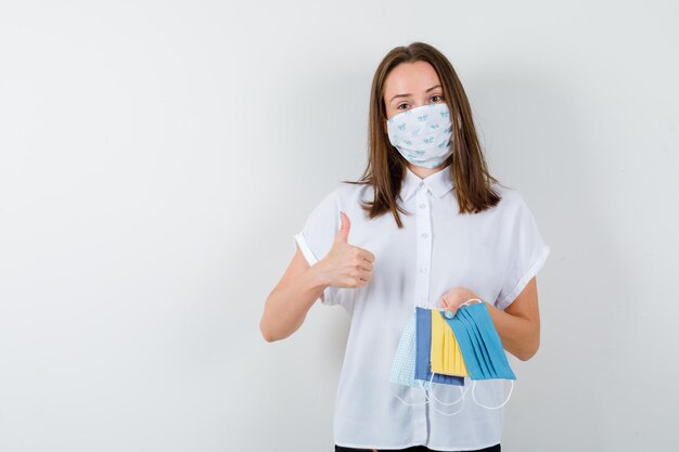 Retrato de jovem segurando máscaras médicas