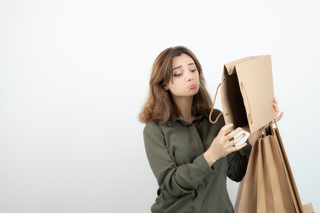 Foto grátis retrato de jovem segurando sacos de papel artesanal e de pé. foto de alta qualidade