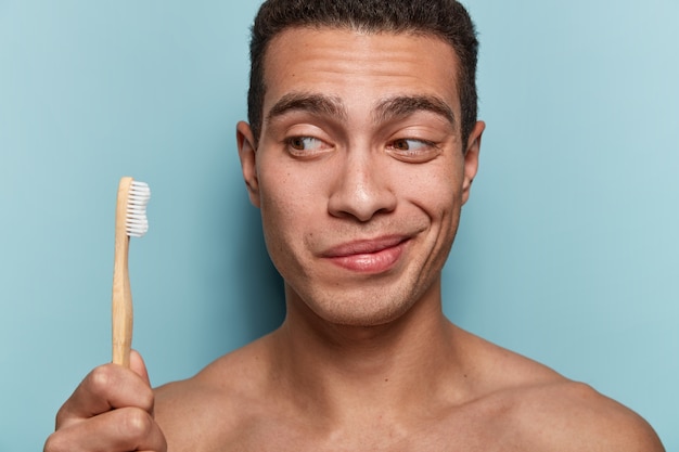 Retrato de jovem segurando uma escova de dentes