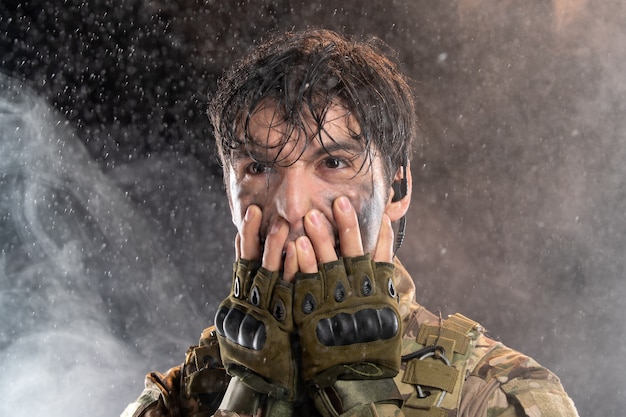 Foto grátis retrato de jovem soldado de uniforme na parede escura