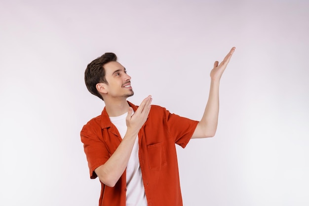 Retrato de jovem sorridente feliz apresentando e mostrando seu texto ou produto isolado no fundo branco