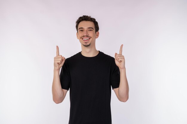 Retrato de jovem sorridente feliz mostrando os polegares para cima gesto e olhando para a câmera isolada sobre fundo branco