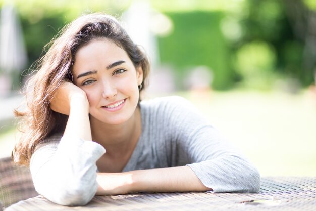 Retrato de jovem sorridente sentado na mesa