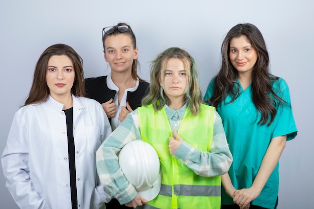 Foto grátis retrato de jovens de diferentes profissões em pé e posando em fundo branco. foto de alta qualidade