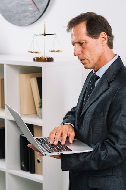 Retrato, de, maduras, advogado masculino, usando computador portátil