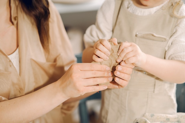 Retrato de mãe e filha juntos a moldar a argila