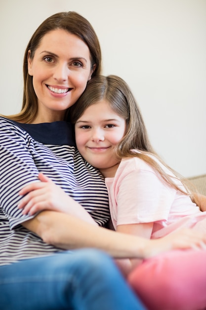 Retrato de mãe e filha que abraçam-se