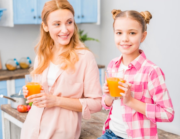 Retrato, de, mãe filha, segurando, suco copo, em, mão