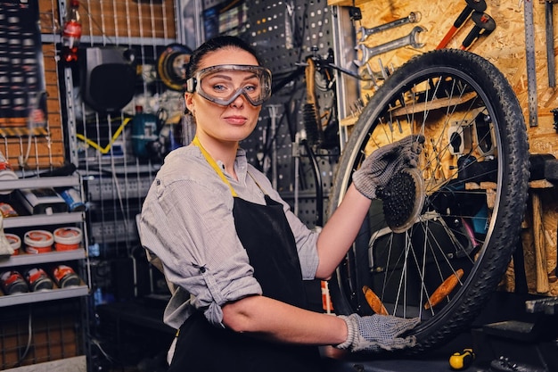 Retrato de mecânico de bicicleta feminina sobre fundo de carrinho de ferramenta.