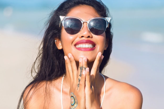 Retrato de menina asiática tailandesa com óculos de sol se divertindo em uma praia tropical