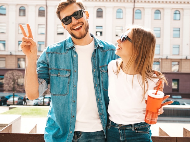 Foto grátis retrato de menina bonita sorridente e seu namorado bonitão em roupas de verão casual. . com garrafa de água e palha