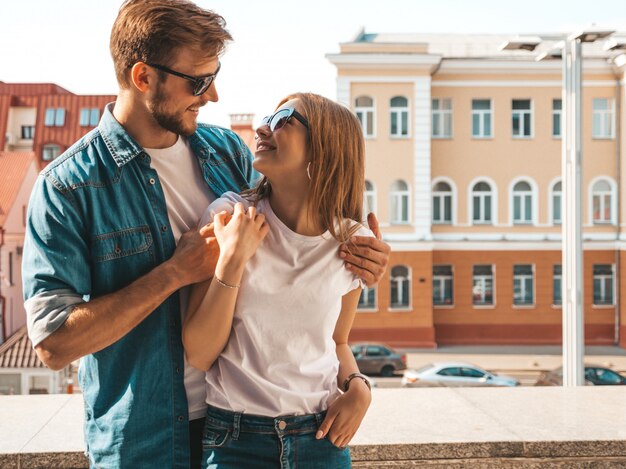 Retrato de menina bonita sorridente e seu namorado bonito em roupas de verão casual e óculos de sol.