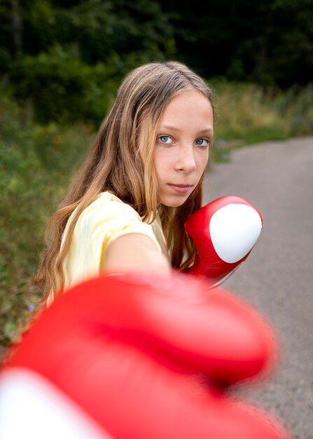 Retrato de menina confiante com luvas de boxe