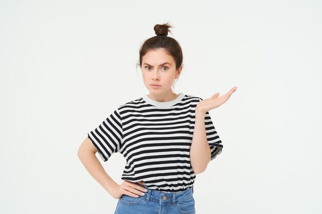 Foto grátis retrato de menina confusa encolhendo os ombros e levantando uma mão parece intrigado não pode entender