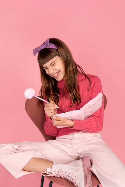 Foto grátis retrato de menina escrevendo em seu caderno e rindo