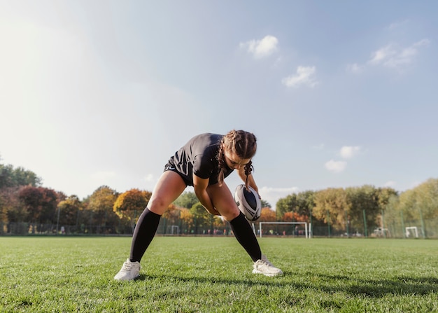 Retrato de menina esportiva segurando uma bola de rugby